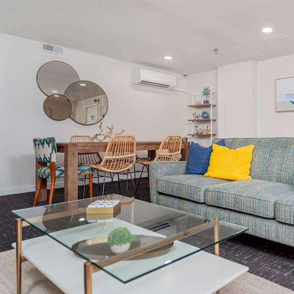 a living room with a blue couch and a glass coffee table. at oak park city, oak park