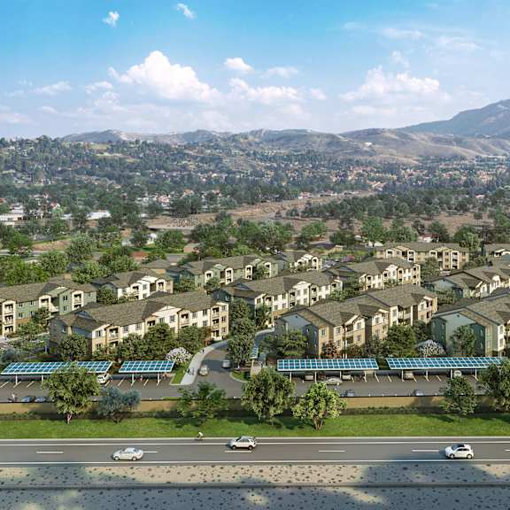 a large housing development with a mountain range in the background.