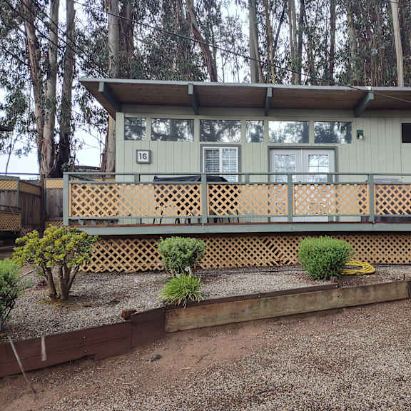 view of a cabin with a deck surrounded by trees at salinas sunset apartments, california