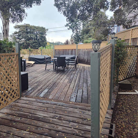 a wooden deck with a lattice fence and a table and chairs at salinas sunset apartments, salinas, 93907