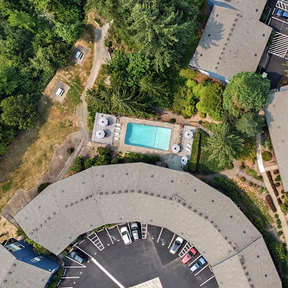 a parking lot with cars and a building with a pool.