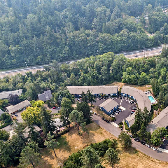a bird's eye view of a parking lot surrounded by trees.