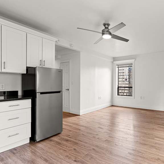 a kitchen with a refrigerator, cabinets, and a ceiling fan at the exeter apartments, apartments, seattle, wa