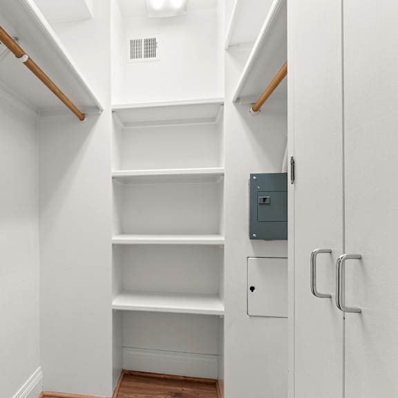 a white closet with shelves and a door at the exeter apartments, seattle