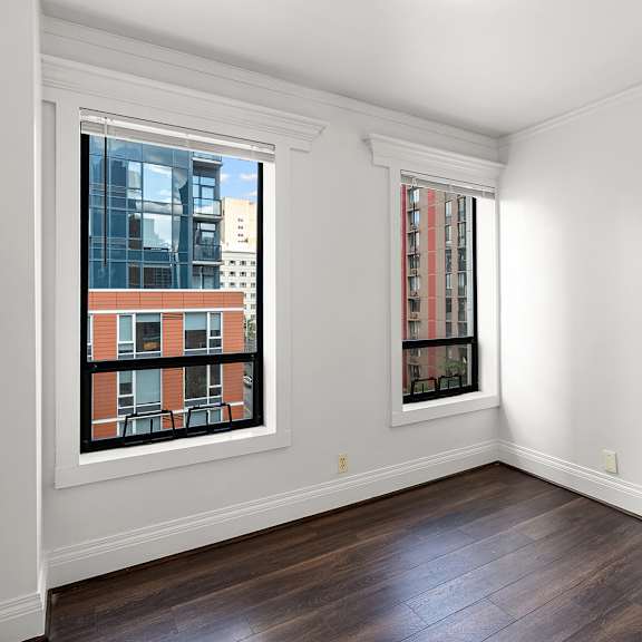 a room with a window showing a building outside at the exeter apartments, seattle, 98101