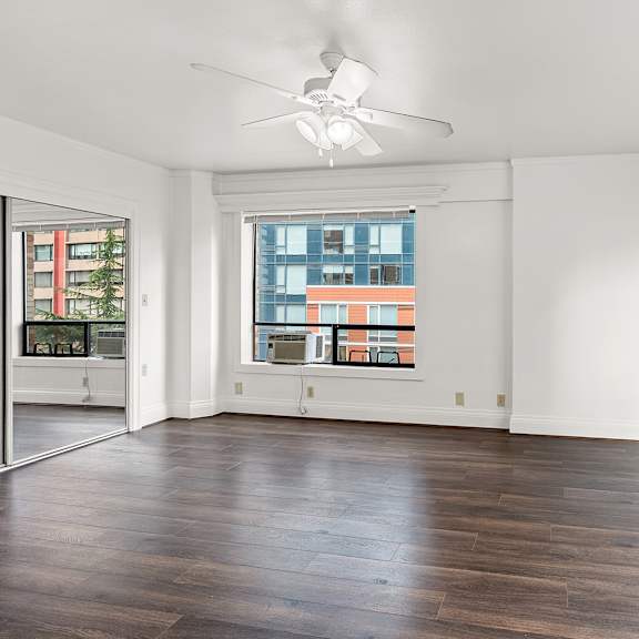 a spacious room with a ceiling fan and large windows at the exeter apartments, washington, 98101