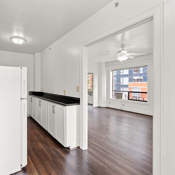 a kitchen with white cabinets and a black countertop at the exeter apartments, seattle