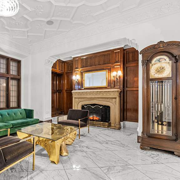 a living room with a green couch, a fireplace, and a large mirror at the exeter apartments, washington, 98101