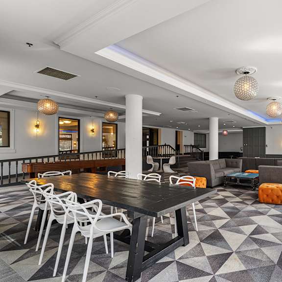 a large room with a black table surrounded by white chairs at the exeter apartments, seattle, wa, 98101