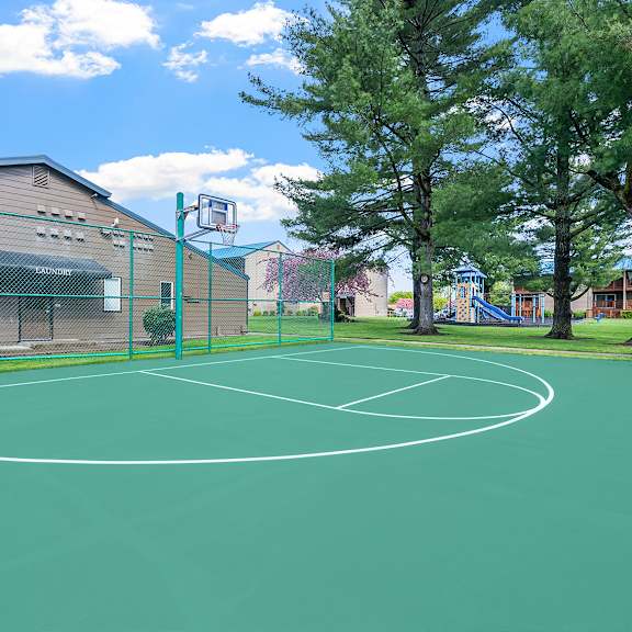 a basketball court is surrounded by a green fence.