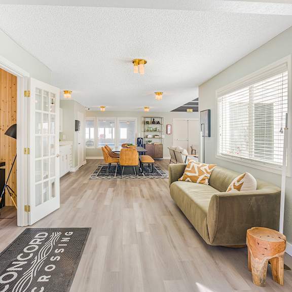 a large room with a couch, chairs, and a rug that says concord crossing.