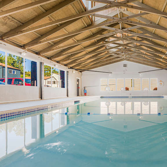 a large indoor swimming pool with a wooden ceiling.