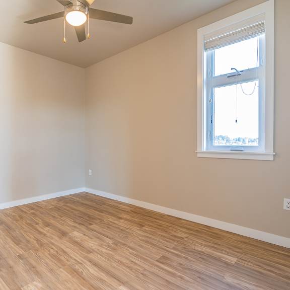 empty bedroom with wood flooring and ceiling fan at brooklyn yard apartments, portland, 97202