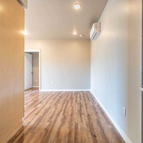 empty bedroom with wood flooring and air conditioner at brooklyn yard apartments, portland