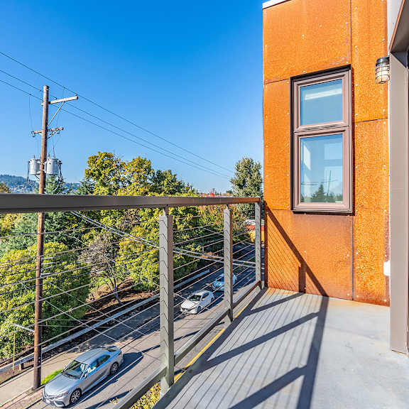 private balcony overlooking residential street and hillside at brooklyn yard apartments, oregon, 97202
