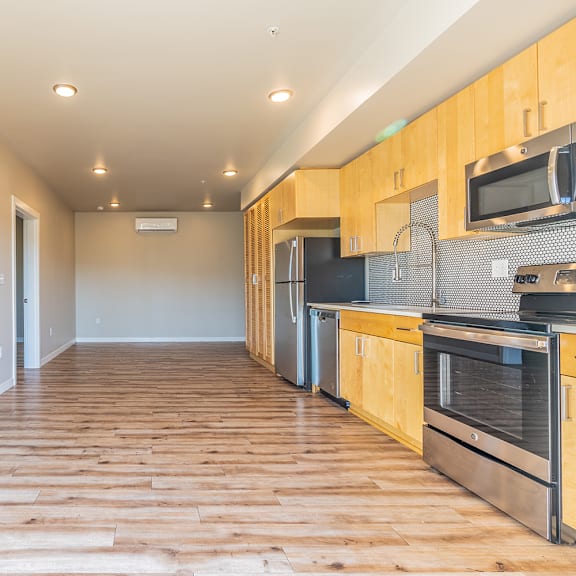 open floor plan with wood flooring and modern kitchen at brooklyn yard apartments, portland, or