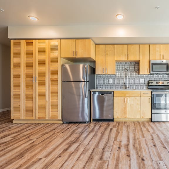 modern kitchen with light wood cabinets and stainless appliances at brooklyn yard apartments, portland