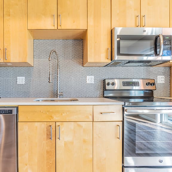 kitchen with penny tile backsplash and modern range at brooklyn yard apartments, oregon, 97202
