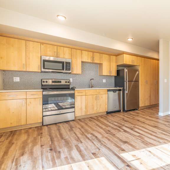 open kitchen with light maple cabinets and wood floors at brooklyn yard apartments, portland