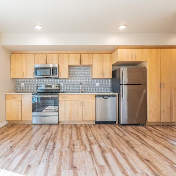kitchen with light wood cabinetry and metallic backsplash at brooklyn yard apartments, oregon, 97202