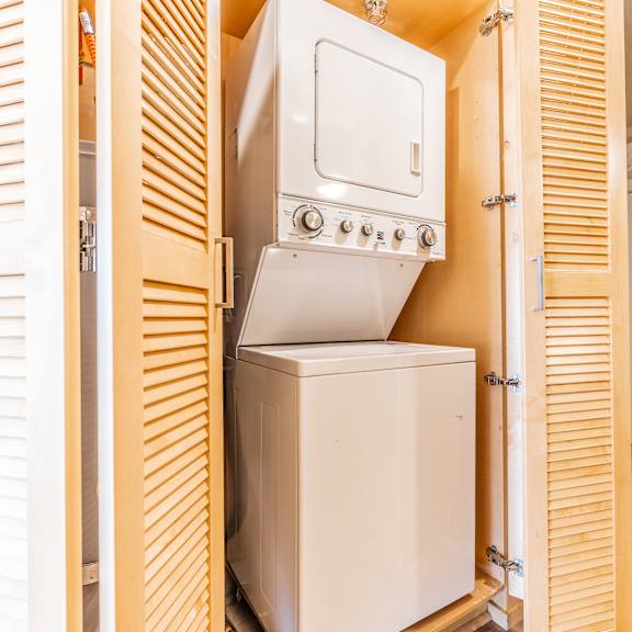 stacked washer dryer unit in closet with louvered doors at brooklyn yard apartments, portland, 97202