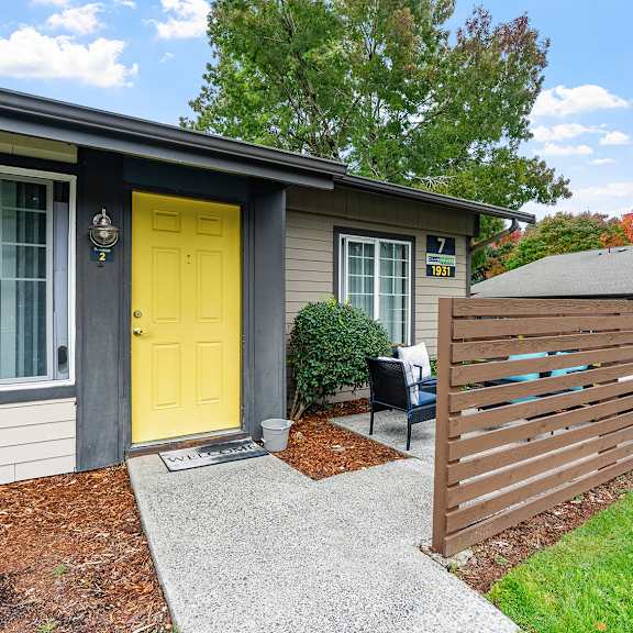 apartment exterior with a yellow door and patio