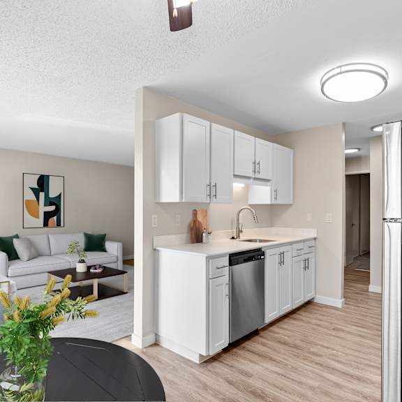 a modern kitchen with white cabinets and a black refrigerator.