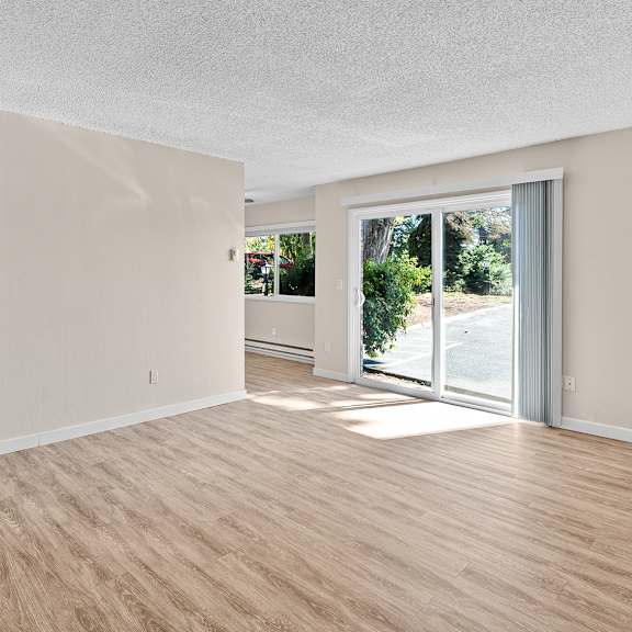 a room with a sliding glass door leading to a backyard.