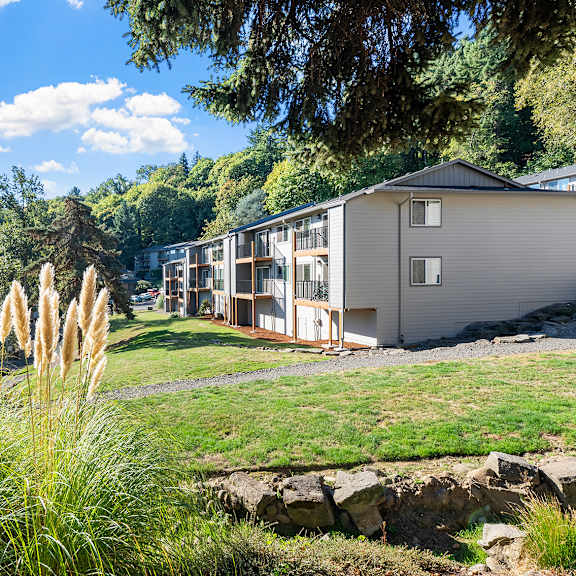 a grassy area with apartments in the background
