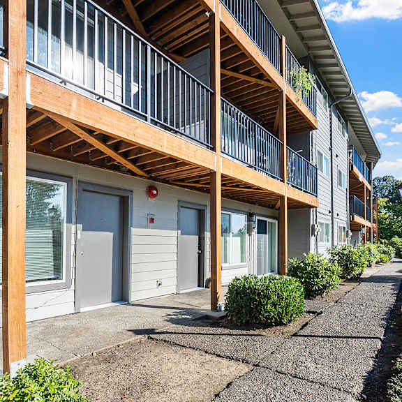 a sunny day at a modern apartment complex with a clear blue sky.