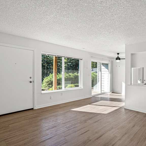 large living room with wooden floors and a view of the kitchen