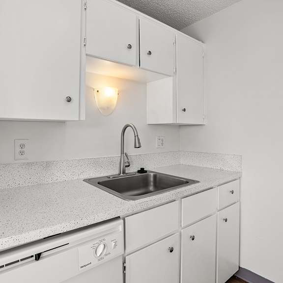 a kitchen with white cabinets and a granite countertop.