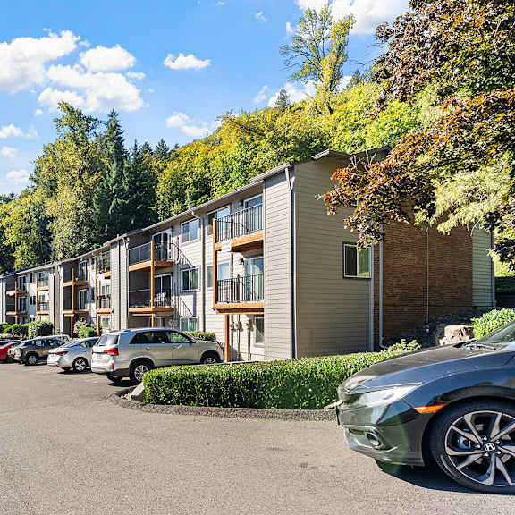apartment exteriors with a parking area and trees