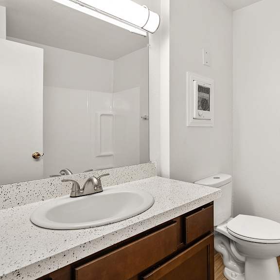a white toilet sits next to a sink in a bathroom.