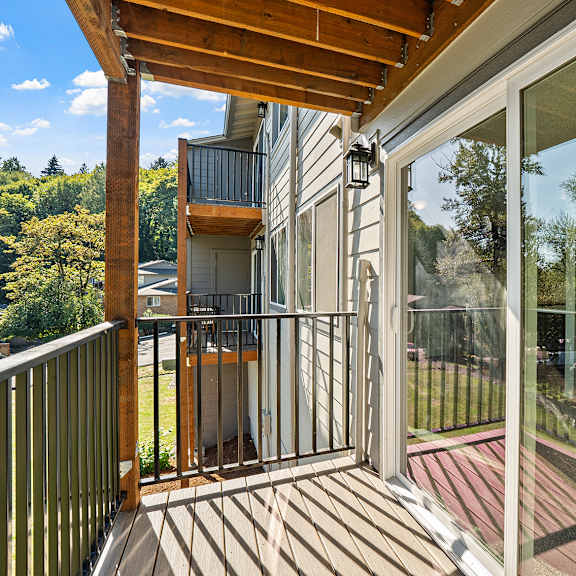 a balcony with a glass door and a wooden railing.
