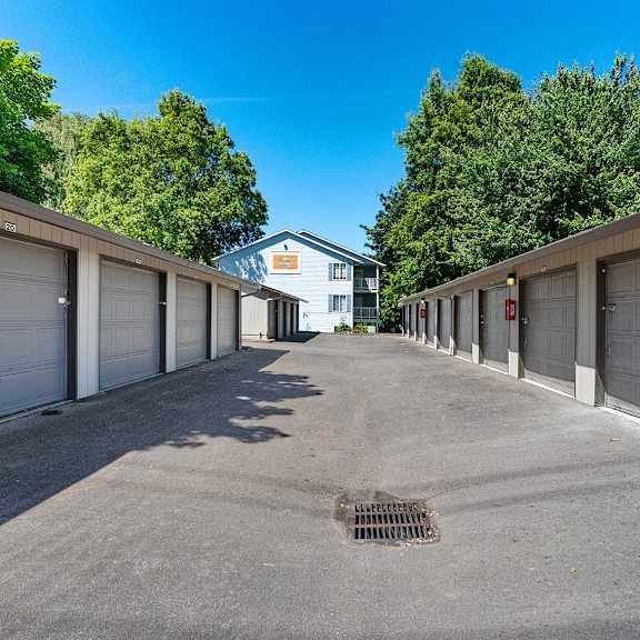a long row of garage doors are open on a sunny day.