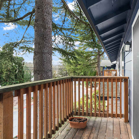 a wooden deck with a pot on it and a glass door.