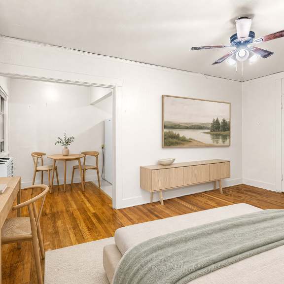 a bedroom with a bed, a table, chairs, and a painting on the wall.