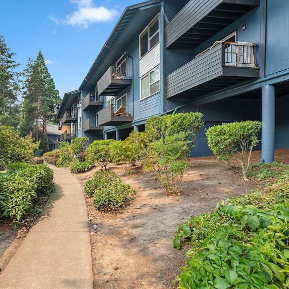 a pathway leads through a landscaped courtyard between two buildings.