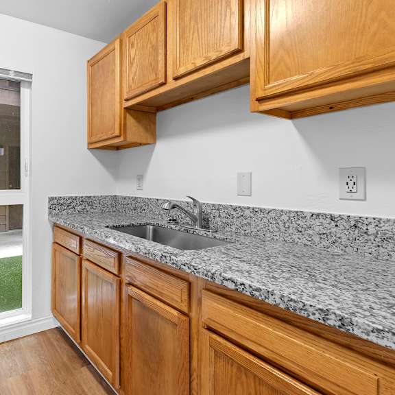 a kitchen with wooden cabinets and granite countertops.at east wind, gresham