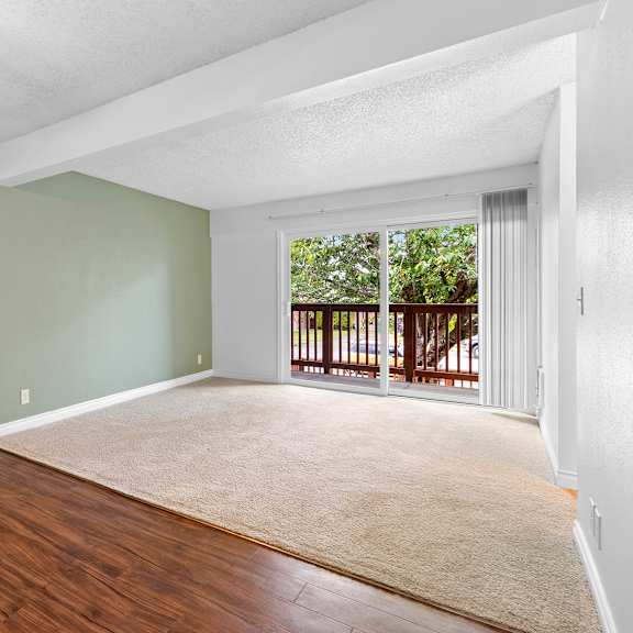 a room with a ceiling fan and sliding glass doors leading to a balcony.at east wind, gresham