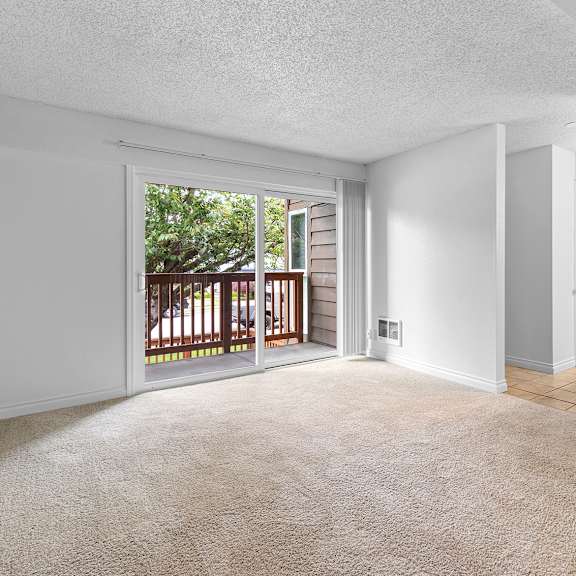 a room with a carpeted floor and a sliding glass door leading to a deck.at east wind, gresham, or