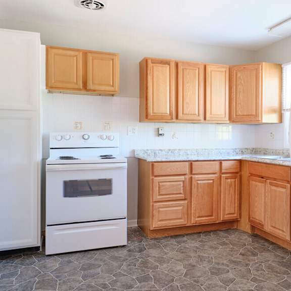 kitchen with white appliances and wooden cabinets at fay street apartments, winchester, va 22601