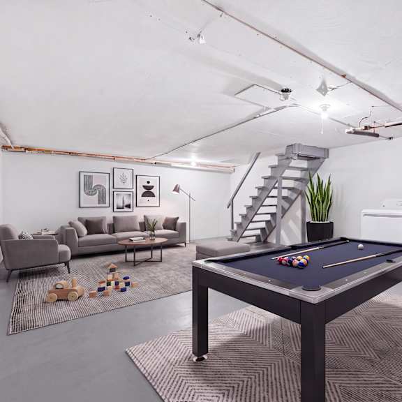 a room with a chair, a sofa, a pool table and a washing machine, and dryer..