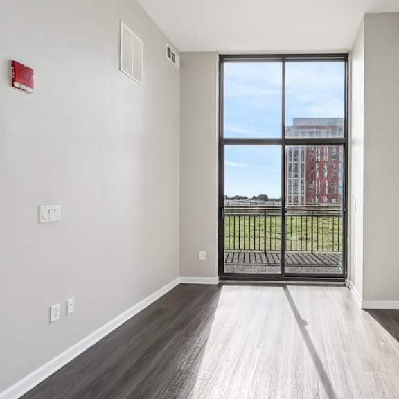 an empty living room with a door to a balcony