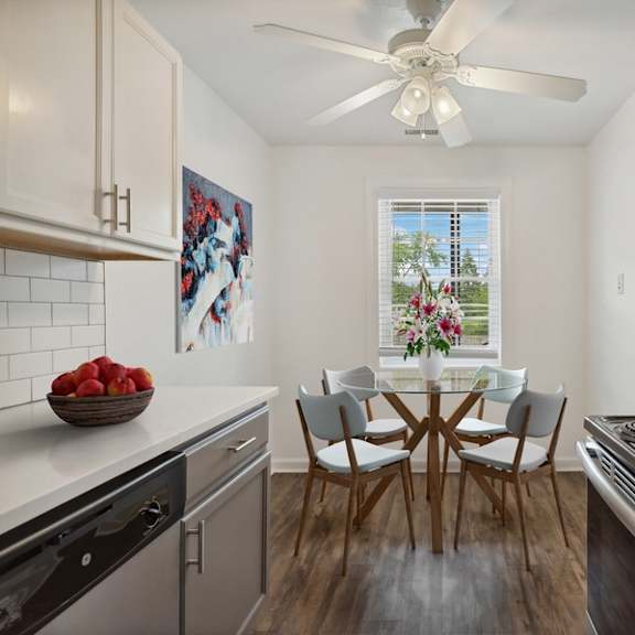 a modern kitchen with a dining table set for four.
