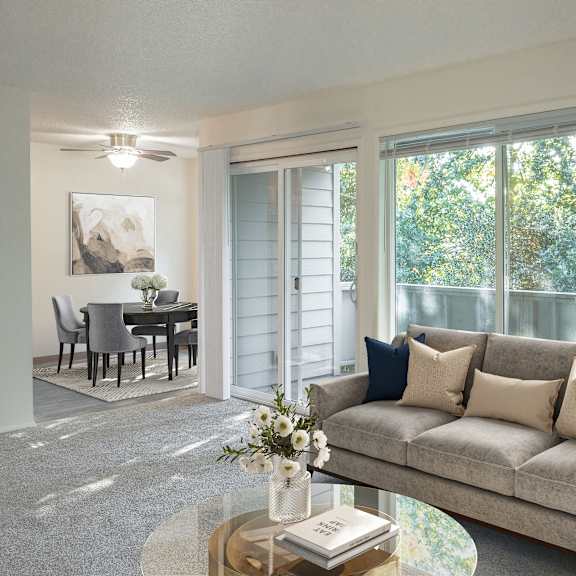 a living room with a grey couch, a coffee table, and a painting on the wall.