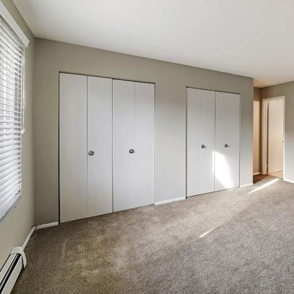 a room with a carpeted floor and white doors.