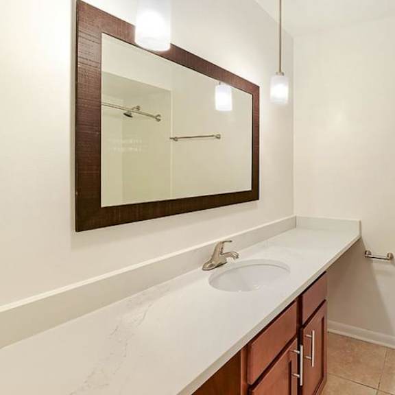 a white bathroom with a toilet, sink, and a mirror.