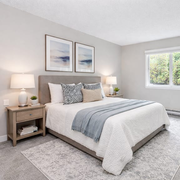 a bedroom with a large bed, a chair, and a potted plant.